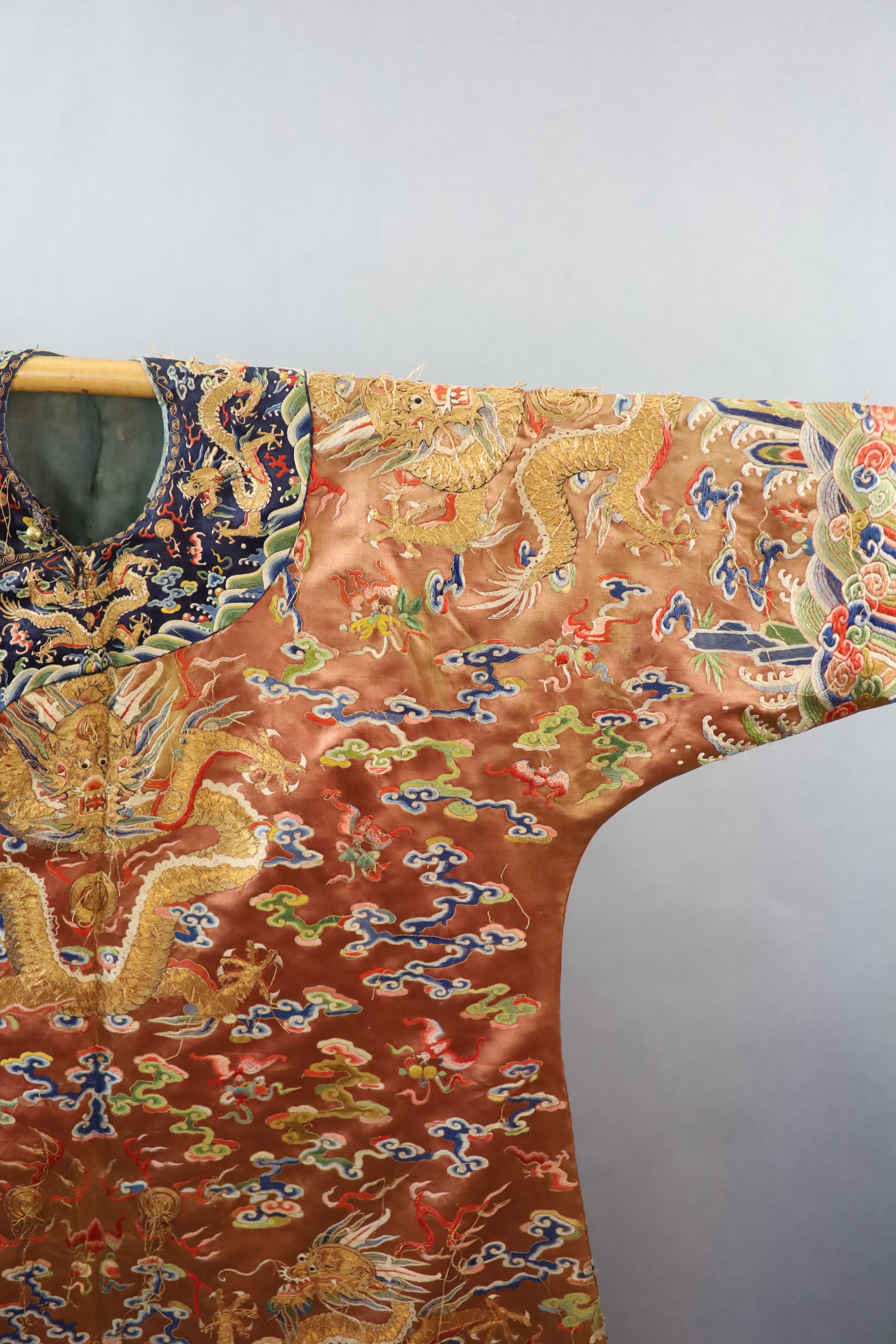 A Chinese apricot embroidered silk ‘dragon’ formal court robe, jifu, late Qing Dynasty, 131cm long, some alterations